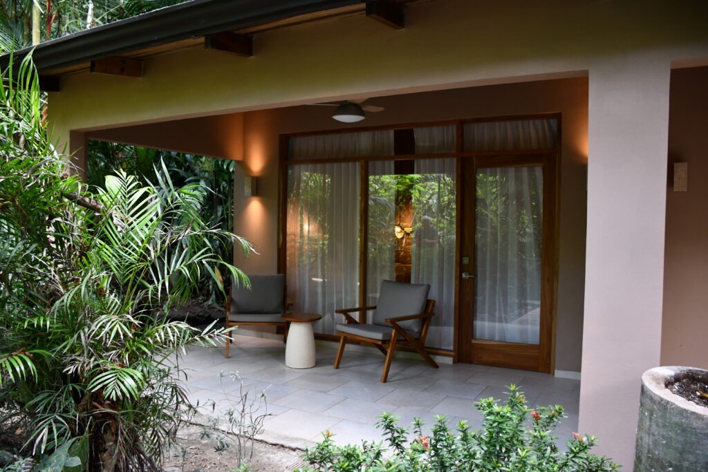Jungle bungalow terrace with lounge chairs surrounded by palms