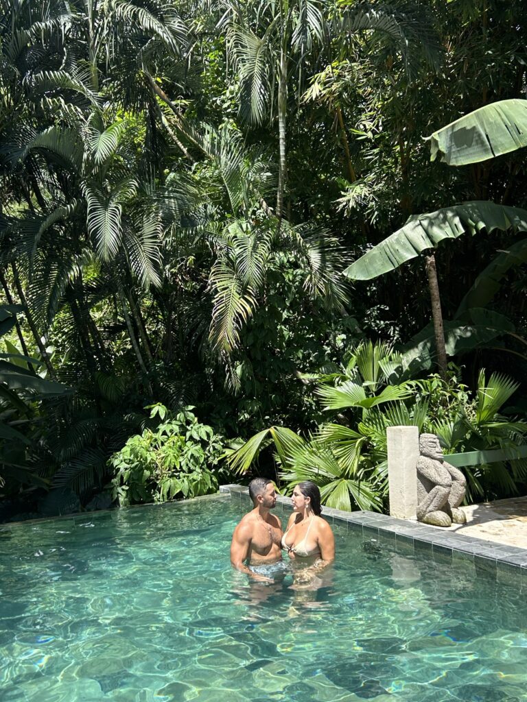 Couple relaxing in the infinity pool surrounded by rainforest
